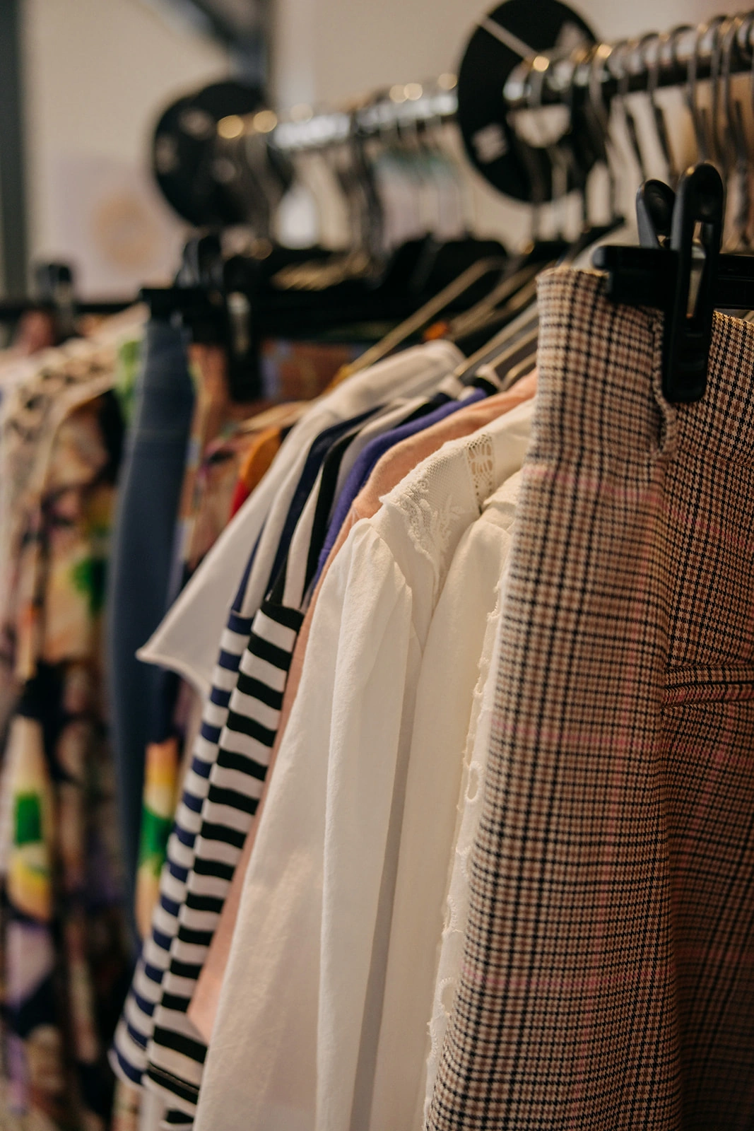 Detailaufnahme verschiedener Kleidungsstücke auf einer Kleiderstange in Cindys Frauenzimmer